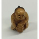 A carved ivory netsuke of a seated man. Est. £40 -