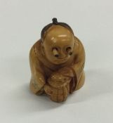 A carved ivory netsuke of a seated man. Est. £40 -