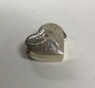 A small silver heart shaped engraved pill box with