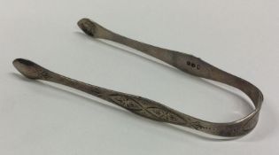 A pair of Georgian silver bright cut sugar tongs.