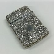 A heavy chased silver card case with scroll decora