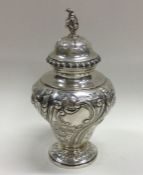 An Edwardian chased silver tea caddy decorated wit