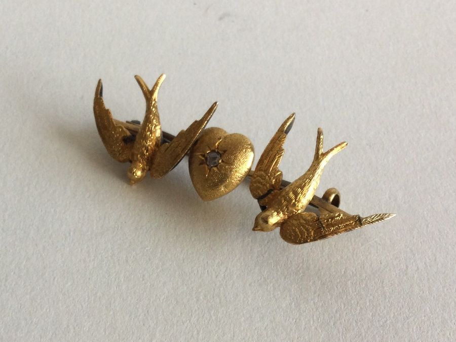 A Victorian gold brooch depicting two doves with h