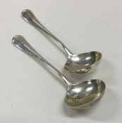 A heavy pair of rat tail pattern silver sauce ladl