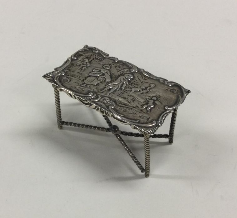 A small silver table toy decorated with a village