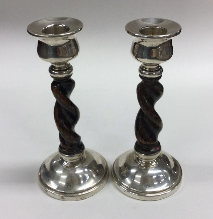 A good pair of oak and silver mounted candlesticks