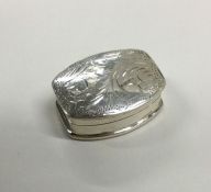 A shaped silver and engraved pill box. Approx. 9 g