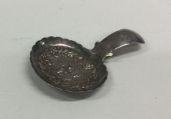 An unusual silver caddy spoon decorated with figur