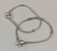 Two modern silver bracelets with heart shaped padl