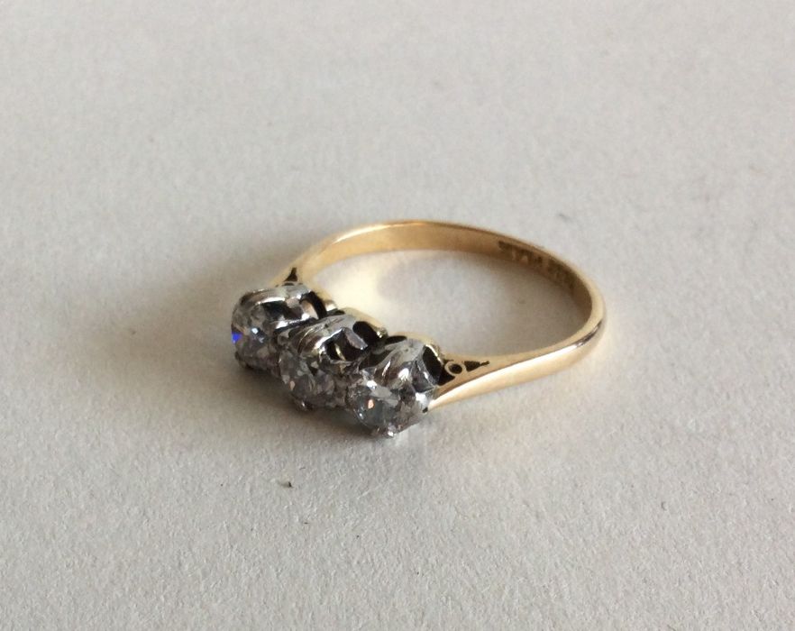 A diamond three stone ring in 18 carat gold and pl