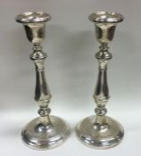 A tall pair of Georgian style silver candlesticks.