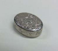A small oval chased silver pill box with swag deco