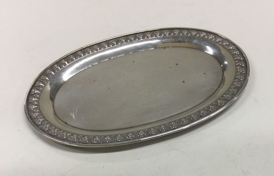 A decorative silver pin tray with crimped border.