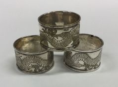 A good set of three Chinese silver napkin rings wi