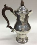 A stylish silver baluster shaped coffee pot with a