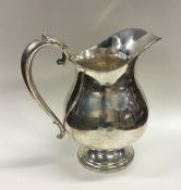 A large Sterling silver beer jug of shaped form. A