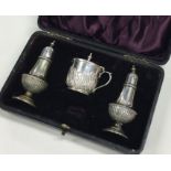 A cased silver plated three piece half fluted crue