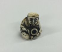 A carved ivory netsuke of a seated man. Est. £40 -