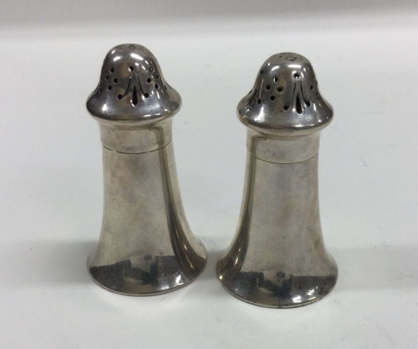 A heavy pair of Edwardian silver peppers with lift