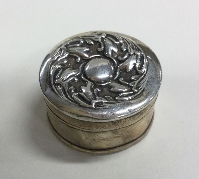 A circular silver pill box of Art Nouveau design.