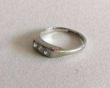 AN unusual diamond three stone ring in white gold