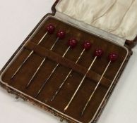 A cased set of six silver gilt cocktail sticks. Es
