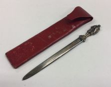 A heavy cast silver letter opener in leather case.