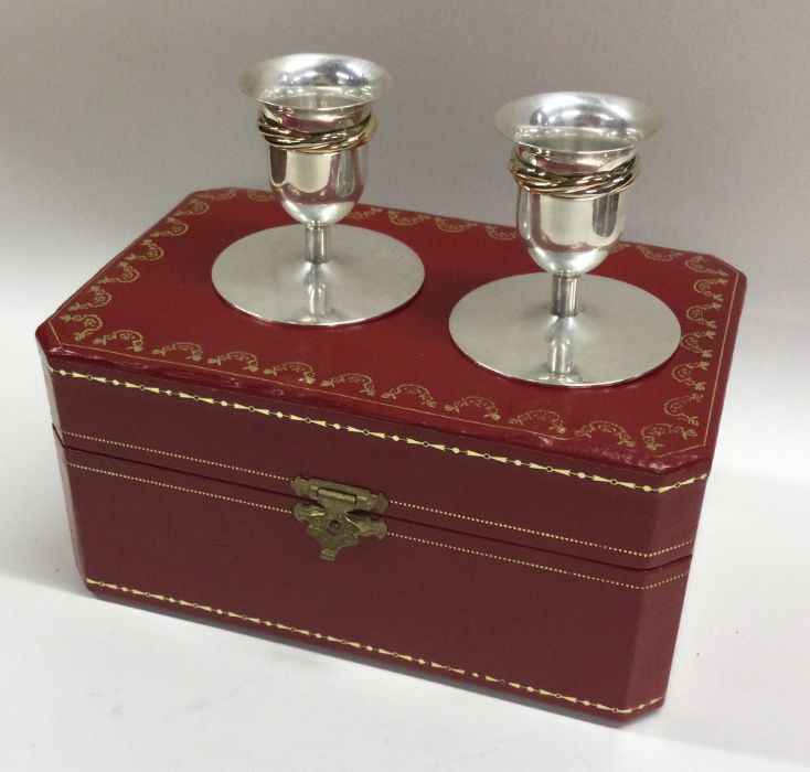 CARTIER: A rare pair of cased silver candlesticks