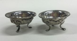 A pair of chased Chinese silver salts decorated wi