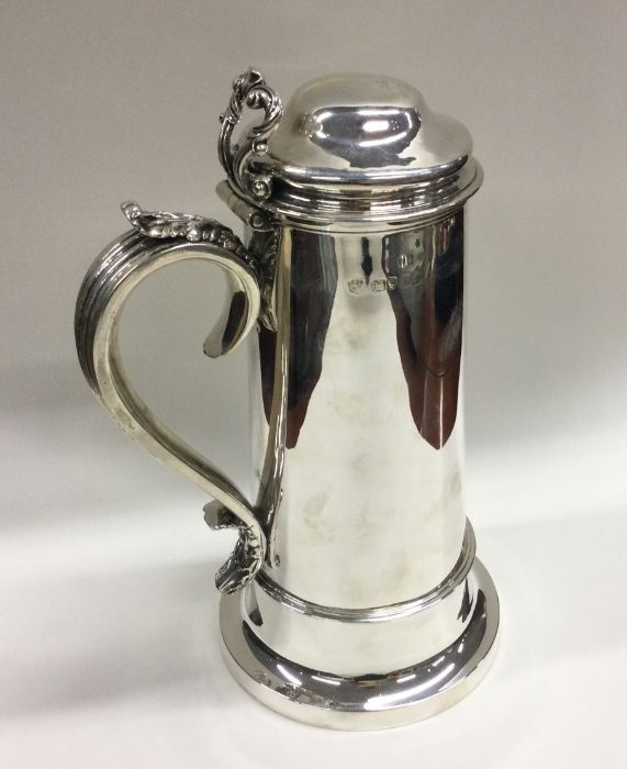 A large tapering silver flagon with scroll and flu