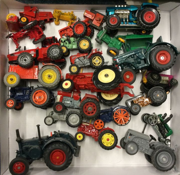 A diecast toy tractor together with other toy trac