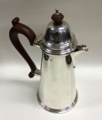 A large tapering silver hot water jug with hinged