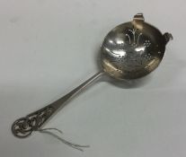 An Edwardian silver tea strainer with pierced hand