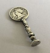 An antique silver pipe tamper with Queen Ann coin.