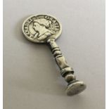 An antique silver pipe tamper with Queen Ann coin.