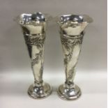 A good pair of embossed silver spill vases of typi