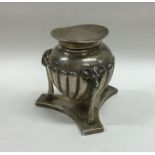 A rare silver hinged top inkwell on shaped base. L