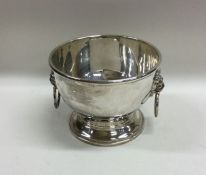 A plain silver two handled bowl decorated with lio