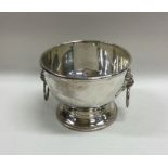 A plain silver two handled bowl decorated with lio