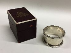 A heavy silver napkin ring contained within a fitt