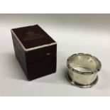 A heavy silver napkin ring contained within a fitt