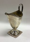 A heavy Georgian silver bright cut cream jug with