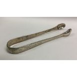 A pair of bright cut silver sugar tongs. London 17