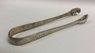 A pair of bright cut silver sugar tongs. London 17