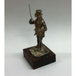 A small silver figure of a man with gun entitled,