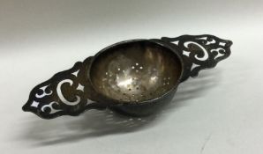 A heavy pierced silver tea strainer of shaped form