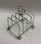 A small silver five bar toast rack on ball feet. S