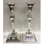 A large pair of square based silver candlesticks w