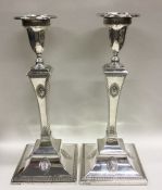 A large pair of square based silver candlesticks w