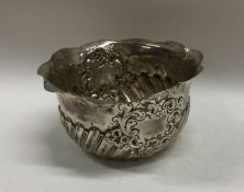 A silver half fluted sugar bowl with shaped rim. L